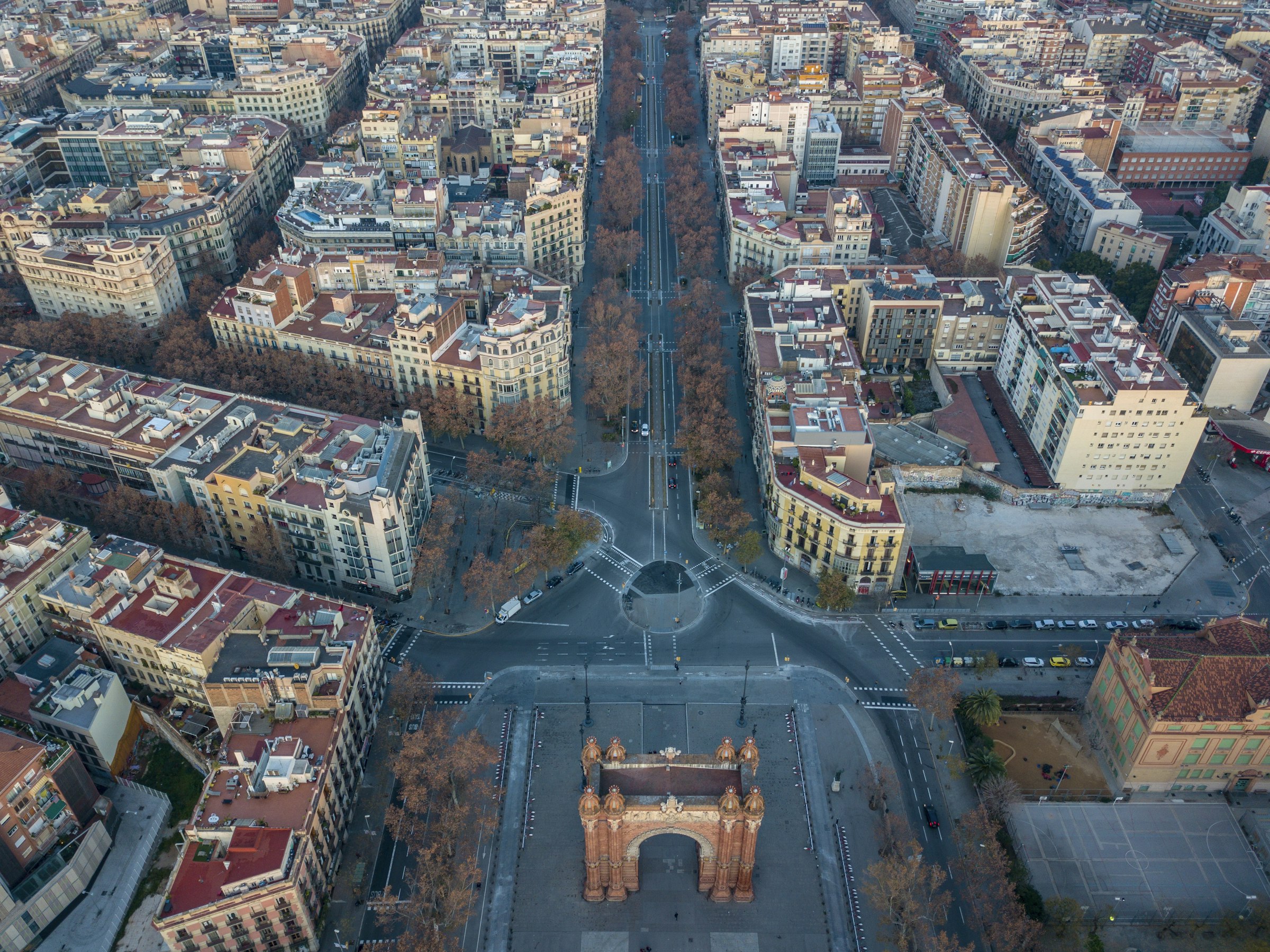 The Arc de Triomf seen from above, with a wide tree-lined avenue running through the grid of the Eixample.