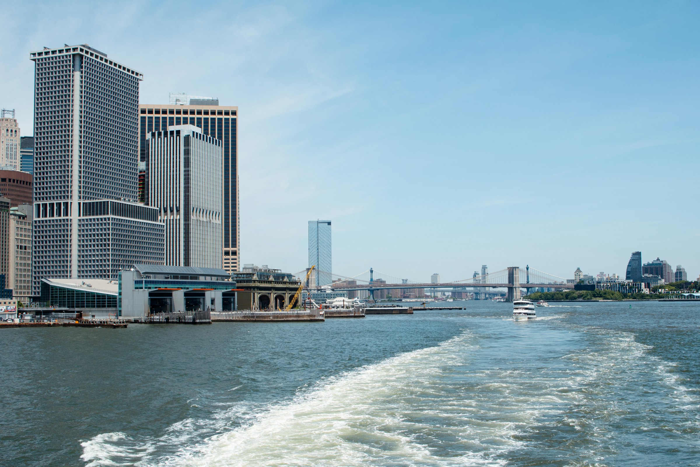 A boat moving down the river past the towers of lower Manhattan.